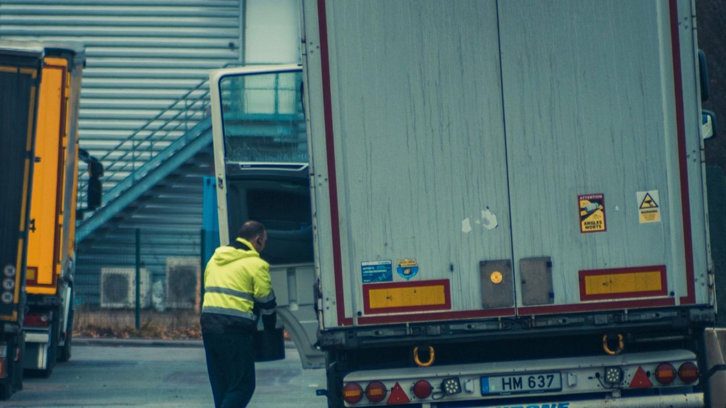 Driver unloading cargo from a trailer