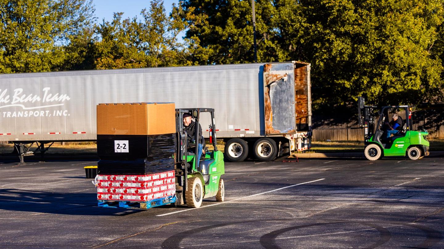 Forklift operators loading a trailer at a dock