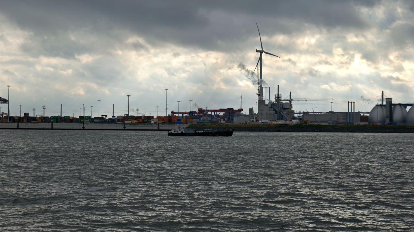 Industrial harbour with a wind turbine behind the quay