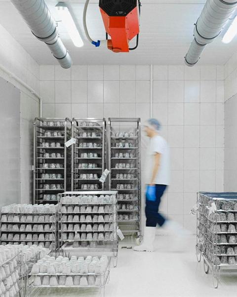 Worker moving racked product inside a cold storage room