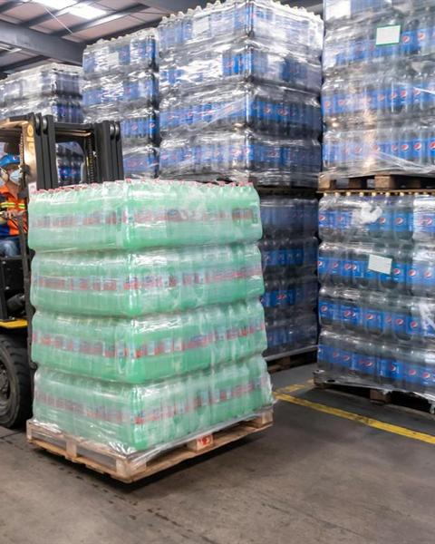 Forklift moving loaded pallets inside a warehouse
