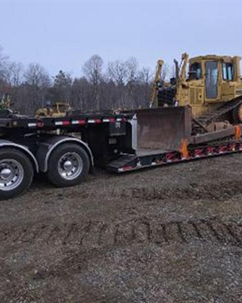 Dozer loaded on a lowboy trailer in the field