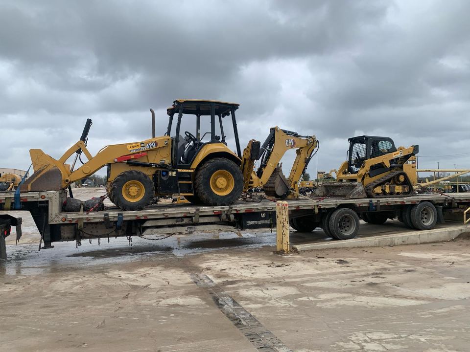 Backhoe loader secured on a trailer for transport