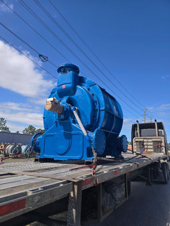 Heavy industrial unit chained on an open-deck trailer