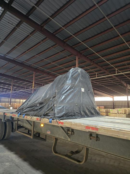 Tarped freight on a flatbed inside a warehouse
