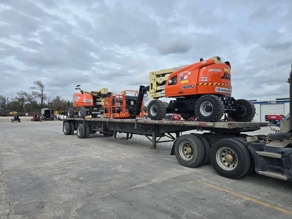 JLG lifts loaded together on a flatbed trailer