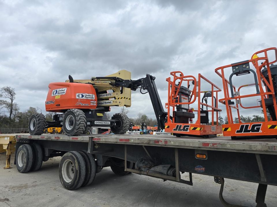 Boom lift and scissor lifts secured on a flatbed