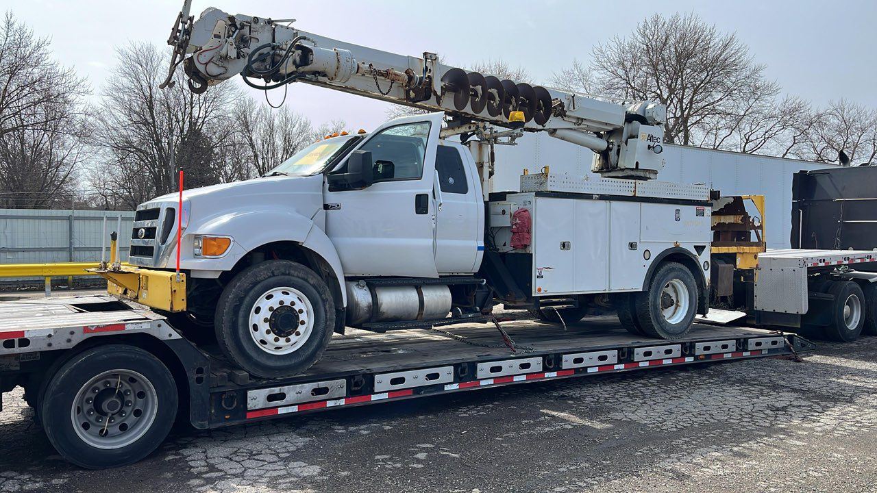 Ford F-750 bucket truck on a step deck trailer