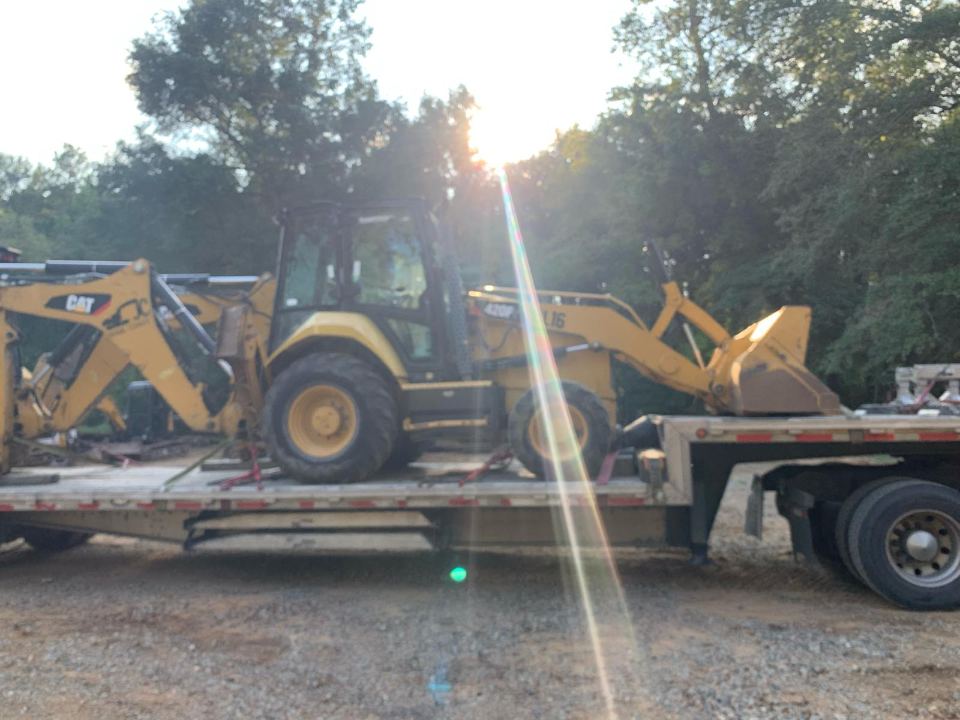 CAT backhoe loader chained down for transport