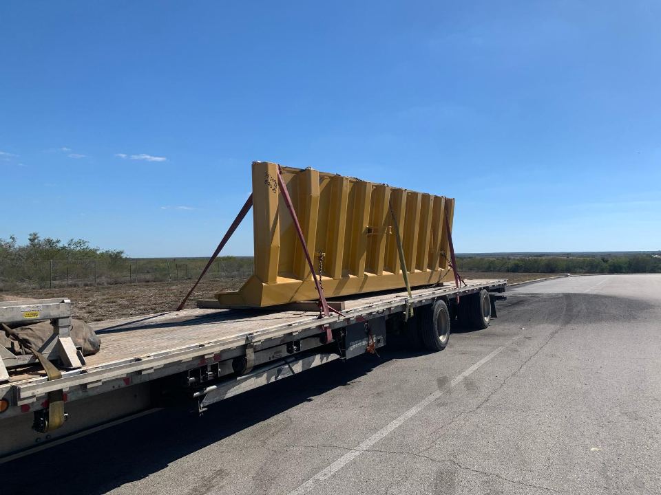 Steel components secured on an open-deck trailer