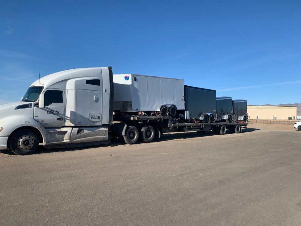 Enclosed freight units in transit on a flatbed
