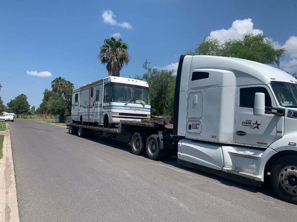 Motorhome being transported behind a semi truck