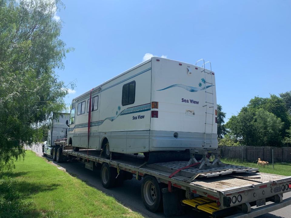 RV loaded on a specialized trailer for transport