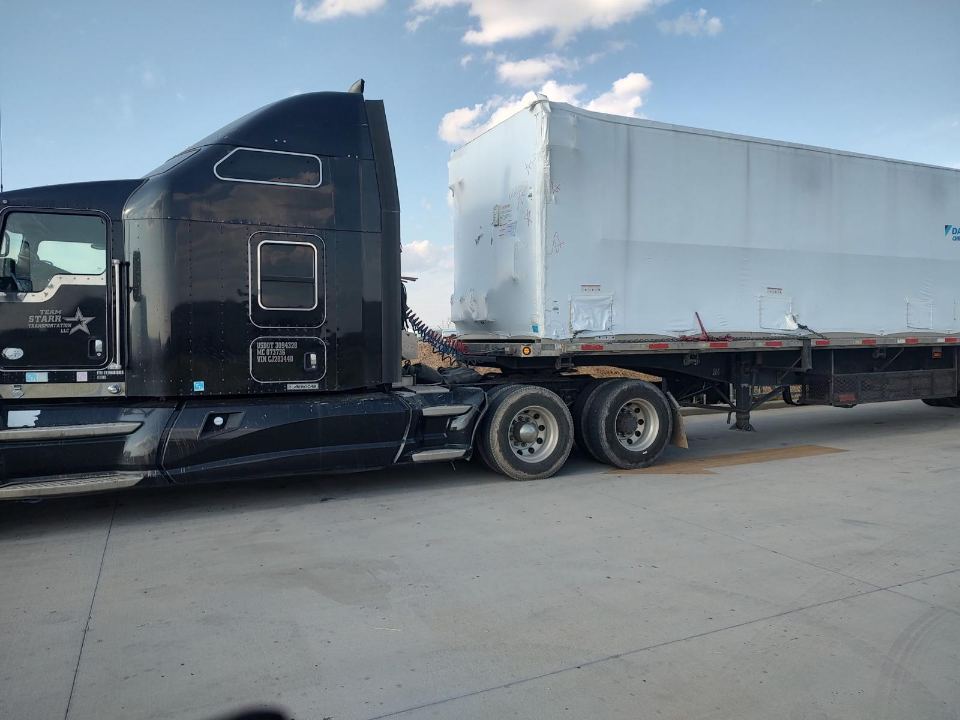 Enclosed container unit on a step deck trailer