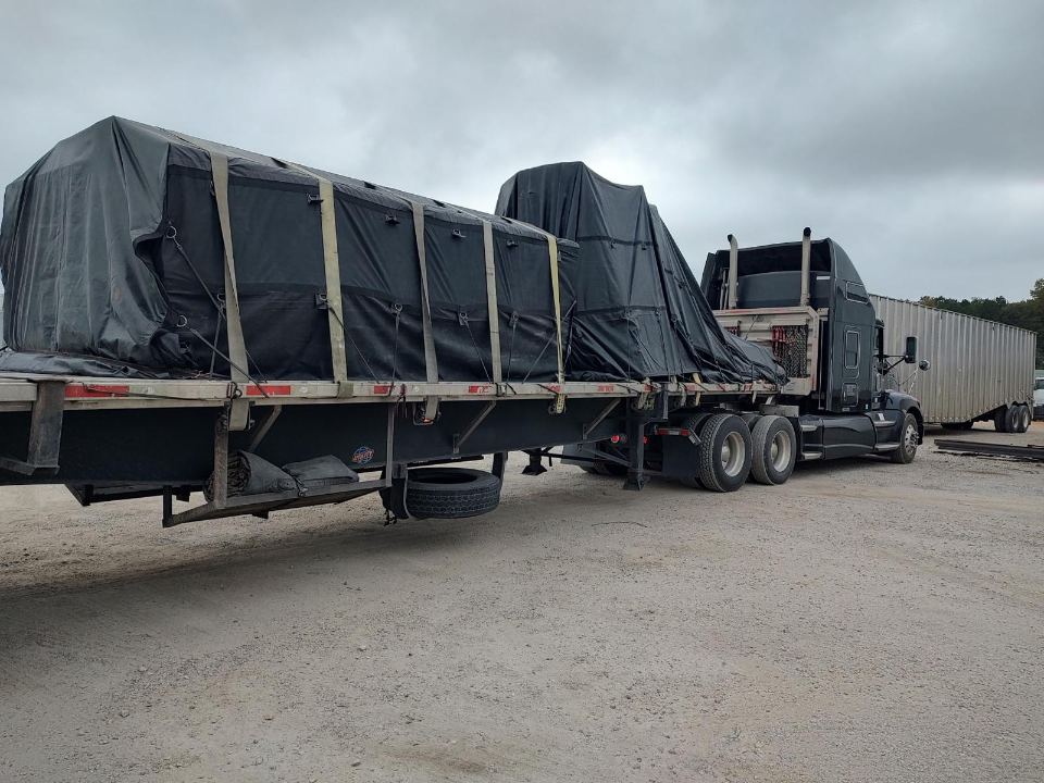Tarped machinery on a flatbed trailer