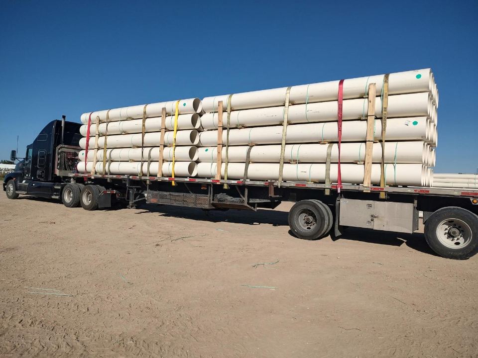 Stacked pipe secured on a flatbed trailer